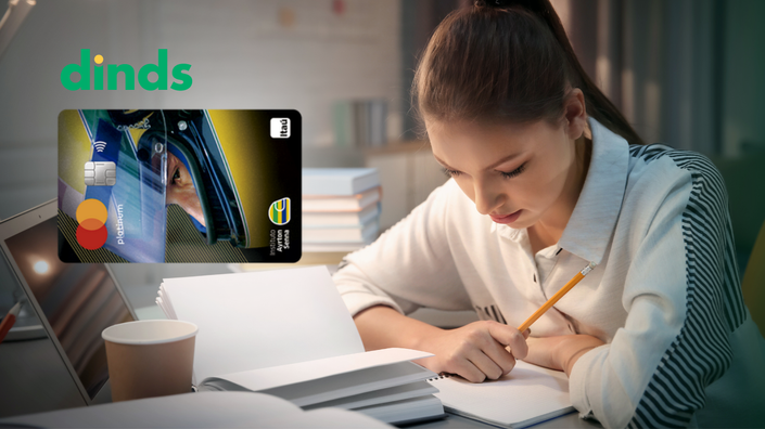 mulher olha para caderno aberto na mesa segurando lápis com livro e noteook abertos na mesa