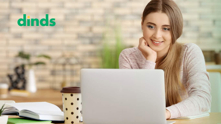 mulher sorri olhando para tela de notebook