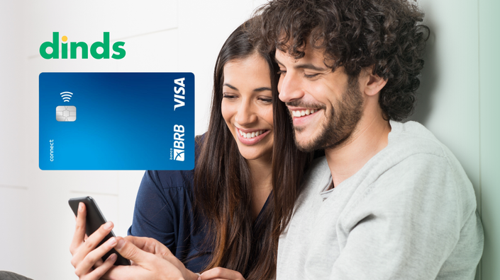 Casal olhando celular juntos e sorrindo com cartao brb connect ao lado
