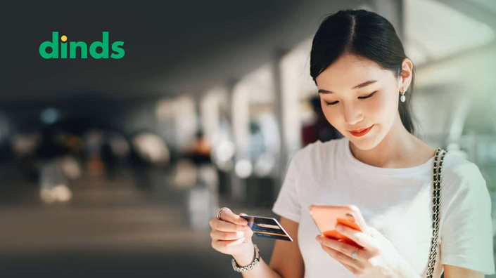 Mulher com celular e cartão de crédito na mão