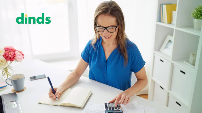 Mulher sorrindo com calculadora e caderno