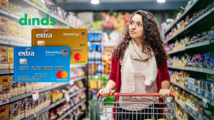 mulher empurra carinho em supermercado olhando para os produtos com cartão extra ao lado