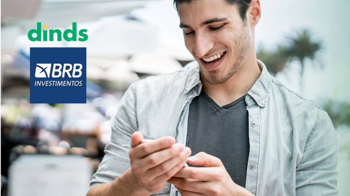 homem osrri mexendo em celular para ver o app da BRB Investimentos