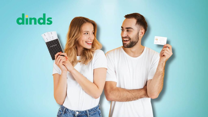 casal se olha segurando passaporte e cartão de crédito