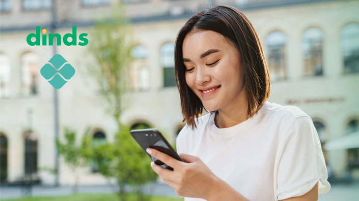 mulher sorri olhando para tela de celular