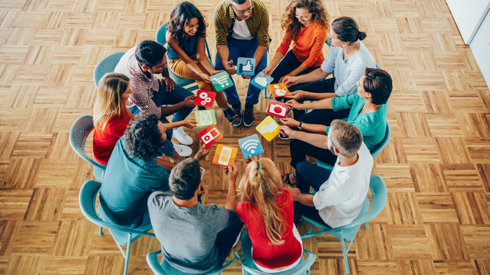 grupo de jovens debatendo tendências financeiras enquanto visualizam informações de redes sociais