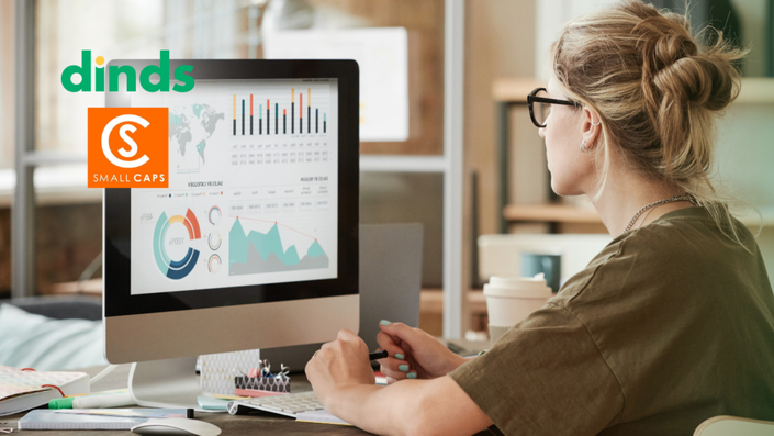 mulher olha para tela de computador com gráficos