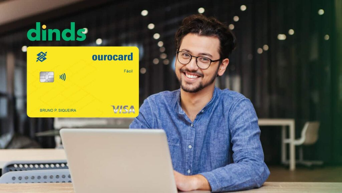 Homem sorrindo com cartão de crédito ourocard ao lado