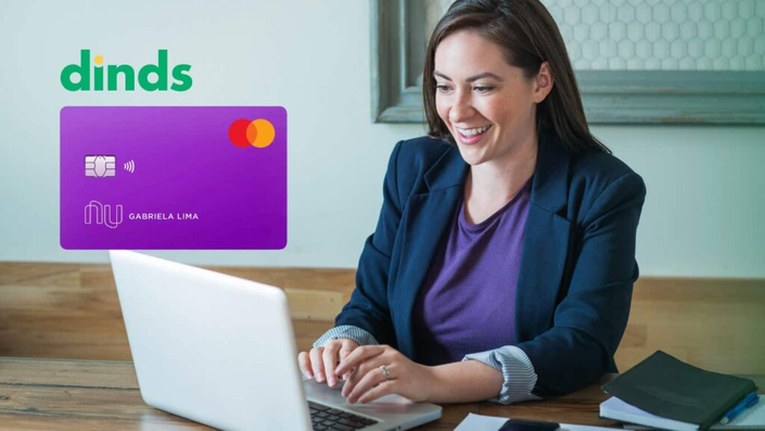 Mulher no computador com cartão nubank ao lado.