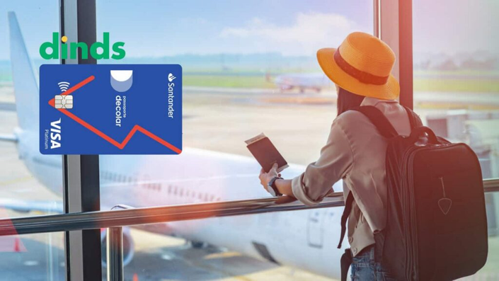 Viajante no aeroporto segurando passaporte ao lado da janela com avião ao fundo, acompanhada do logotipo Dinds e cartão Santander Decolar Visa Platinum.