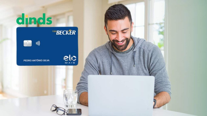 Homem sorridente usando laptop ao lado da imagem do cartão Lojas Becker Elo Mais e logo do Dinds.