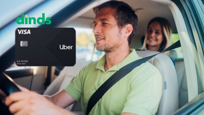 Motorista dirigindo com passageira sorridente ao fundo, ao lado da imagem do cartão Uber Visa e logo do Dinds.