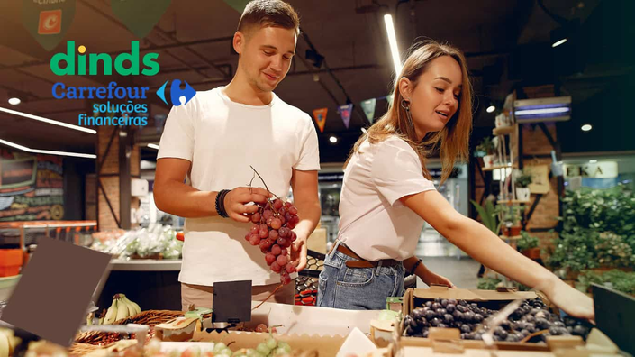 Casal em um mercado com logo do carrefour ao lado