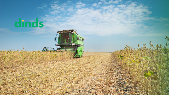 imagem de um campo de soja ou milho com maquinário agrícola em ação, enfatizando o investimento no agronegócio